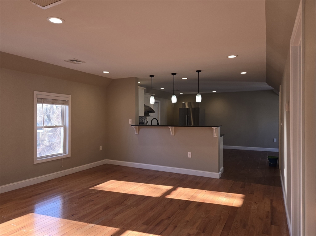 3 Pearl Street, Unit 2 Stoneham, MA 02180 - Photo 10 of 21 an empty room with wooden floor and windows