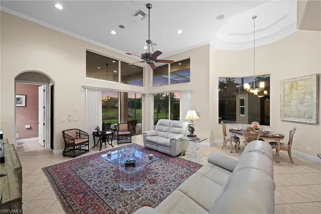 a living room with furniture a large window and a chandelier