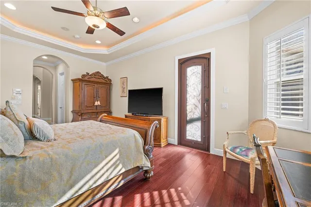 a bedroom with a bed next to a window with a flat screen tv