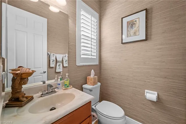 a bathroom with a sink mirror and toilet