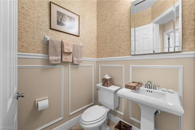 a white toilet sitting next to a bathroom sink