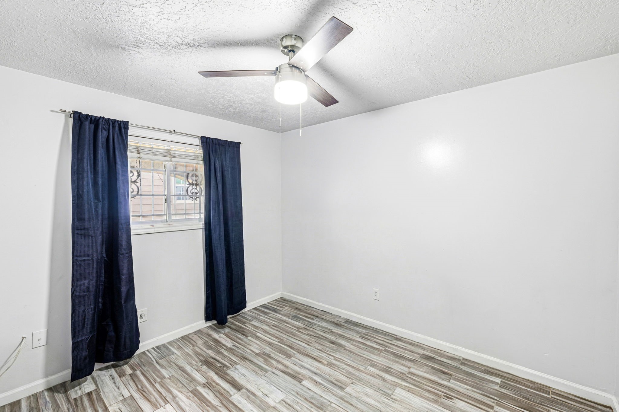 4422 Sandydale Lane Houston, TX 77039 - Photo 14 of 36 a view of a bedroom with wooden floor and a ceiling fan
