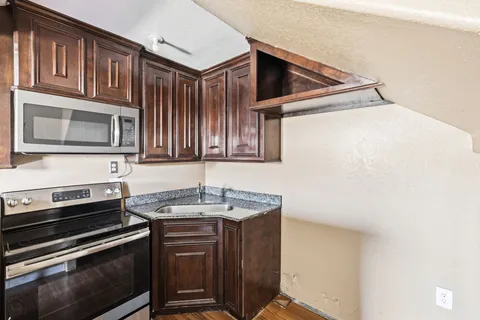 a kitchen with wooden cabinets and a stove top oven