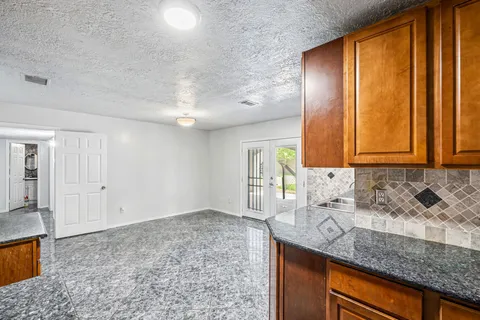 a bathroom with a granite countertop sink and a mirror