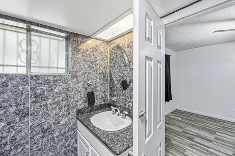a bathroom with a granite countertop sink and a mirror