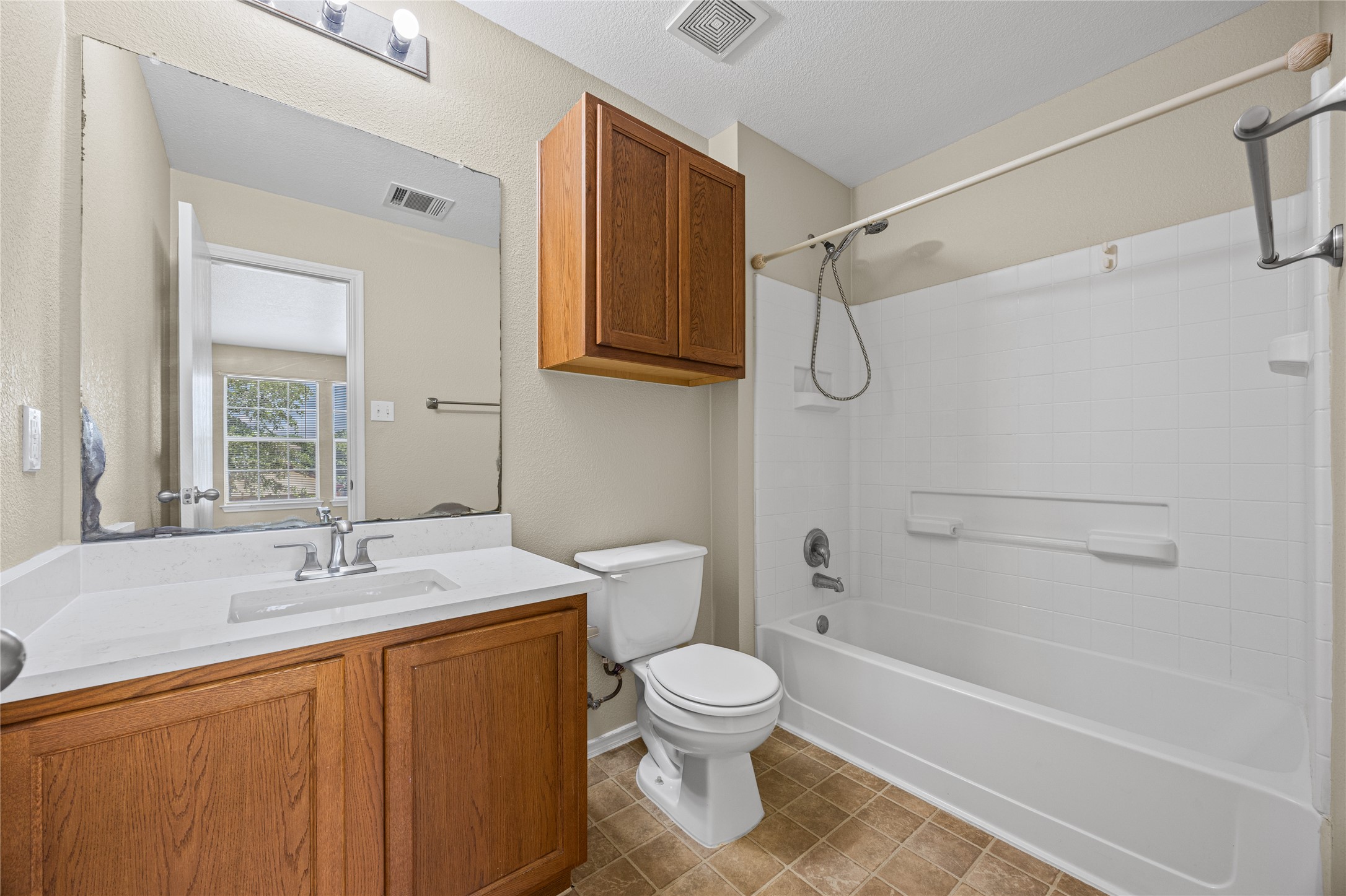 198 Black Forest Road Buda, TX 78610 - Photo 19 of 23 A classic bathroom featuring a white vanity with ample storage and a combination tub-shower.