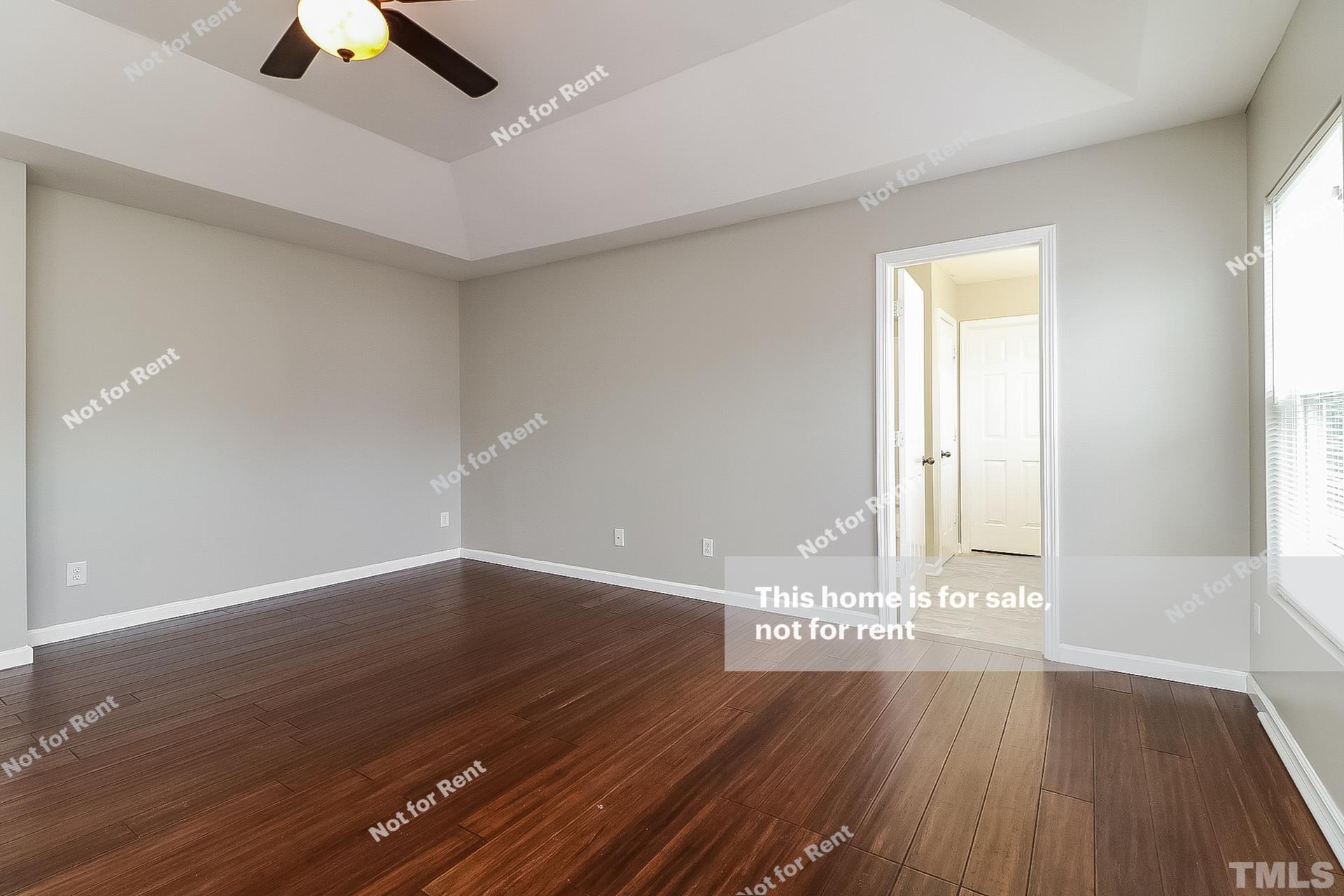 115 Cinder Cross Way Garner, NC 27529 - Photo 13 of 27 an empty room with wooden floor chandelier fan and windows