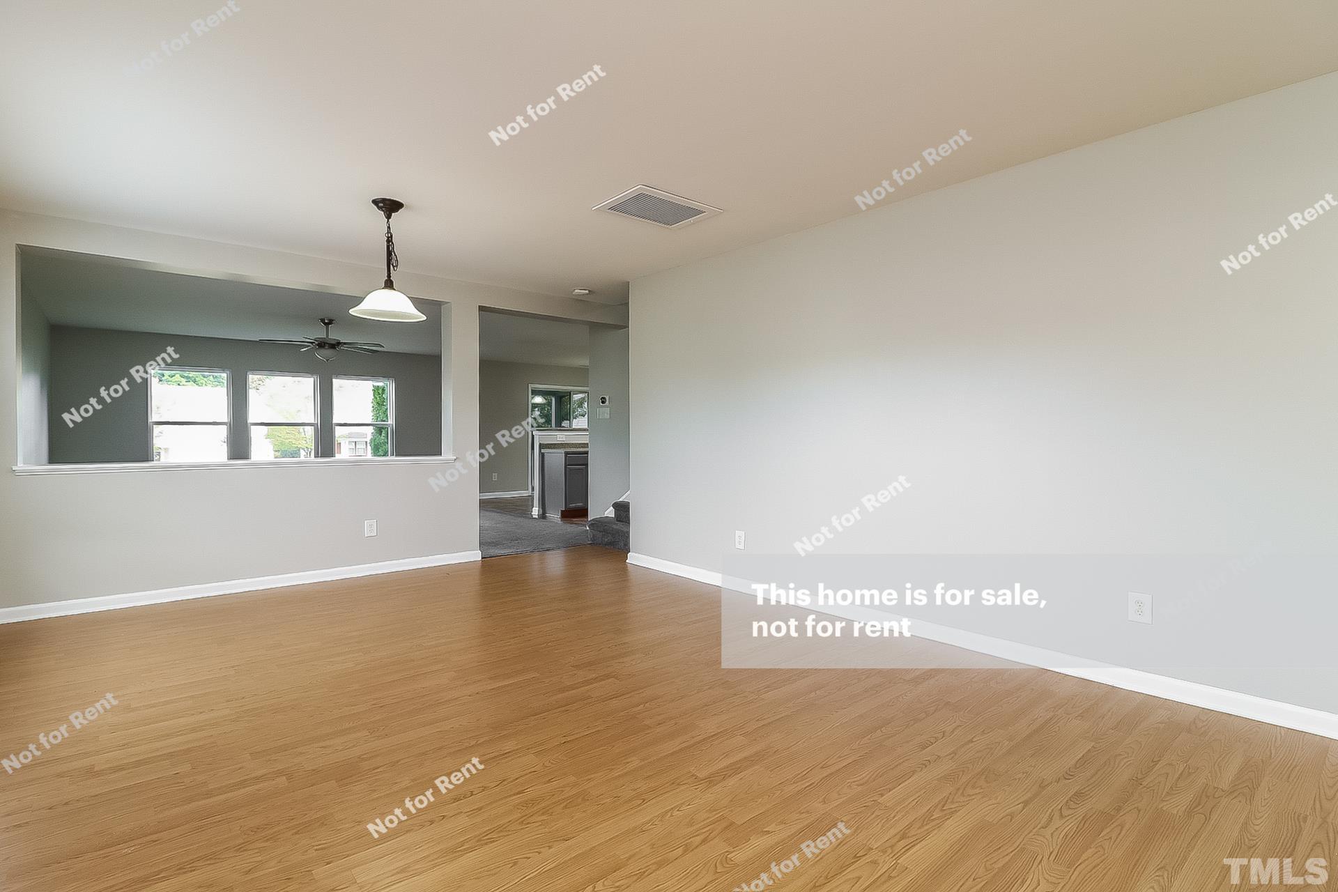 115 Cinder Cross Way Garner, NC 27529 - Photo 10 of 27 a view of an empty room with wooden floor and a kitchen
