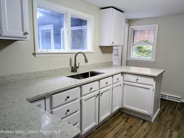 a kitchen with granite countertop white cabinets and white appliances