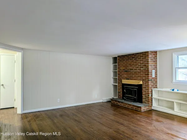 a view of empty room with wooden floor and fireplace