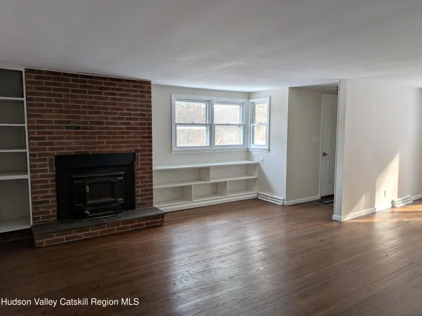 a view of a livingroom with wooden floor and a fireplace