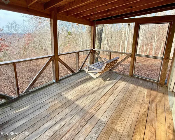 a view of a patio with table and chairs with wooden floor and fence