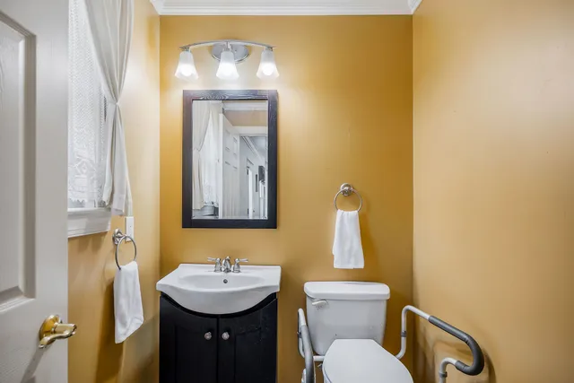 a bathroom with a toilet sink and mirror
