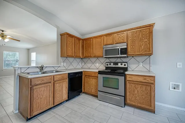 a kitchen with stainless steel appliances granite countertop a stove a sink and a microwave