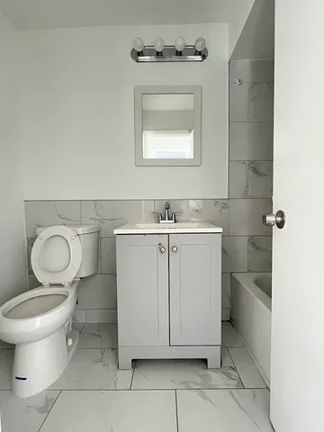 a bathroom with a toilet sink and mirror