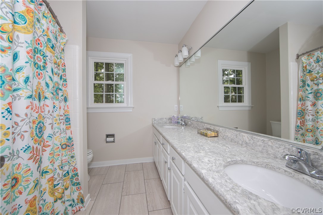 14211 Helmsley Road Midlothian, VA 23113 - Photo 36 of 47 a bathroom with a granite countertop sink a mirror a vanity and a shower
