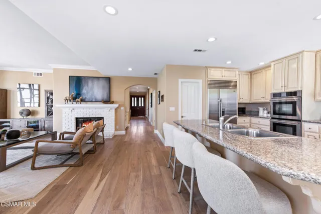 a kitchen with stainless steel appliances granite countertop a stove a sink a microwave a dining table and chairs