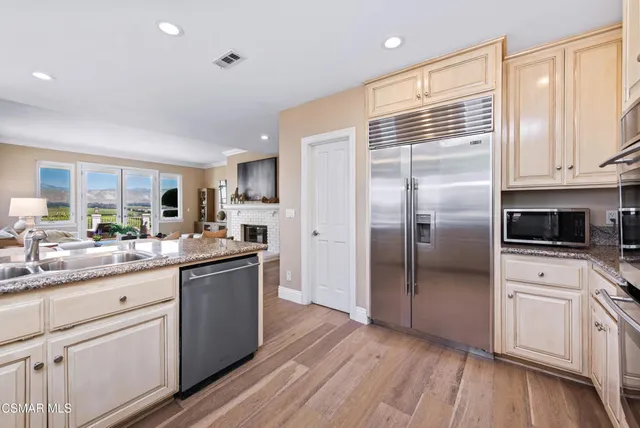 a kitchen with stainless steel appliances granite countertop a stove a sink a dining table and chairs