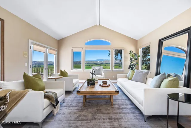 a living room with furniture a fireplace and a large window