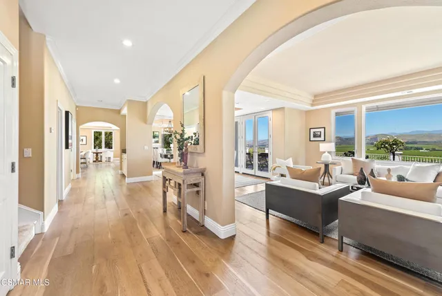 a living room with furniture kitchen view and large windows
