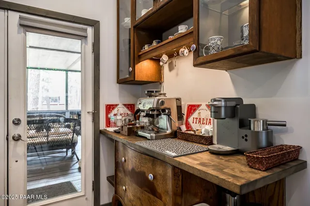 a kitchen with stainless steel appliances a dining table chairs stove refrigerator and cabinets