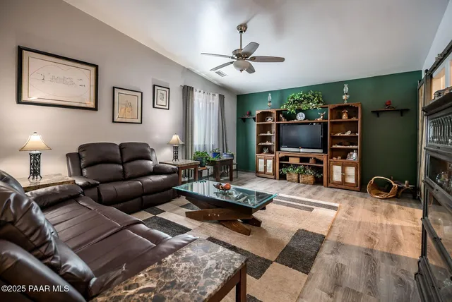 a living room with furniture a flat screen tv and a window
