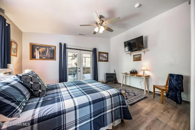 a bedroom with a large bed a flat tv screen and dresser