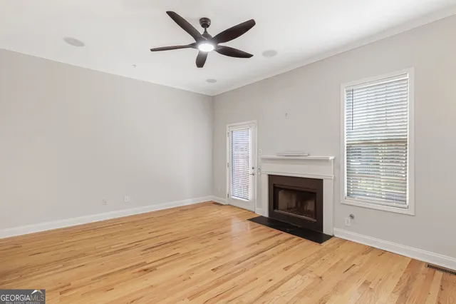 an empty room with windows a fireplace