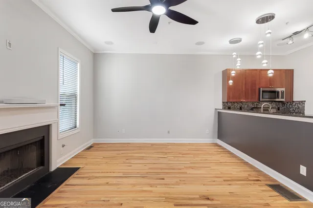 a view of an empty room with a kitchen and a fireplace