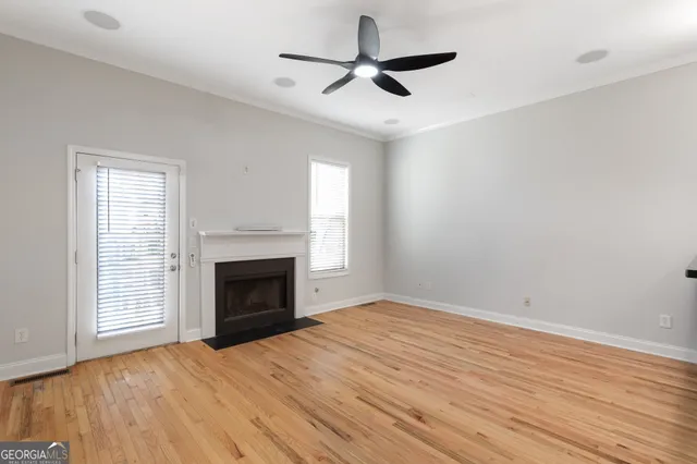 an empty room with windows and fireplace