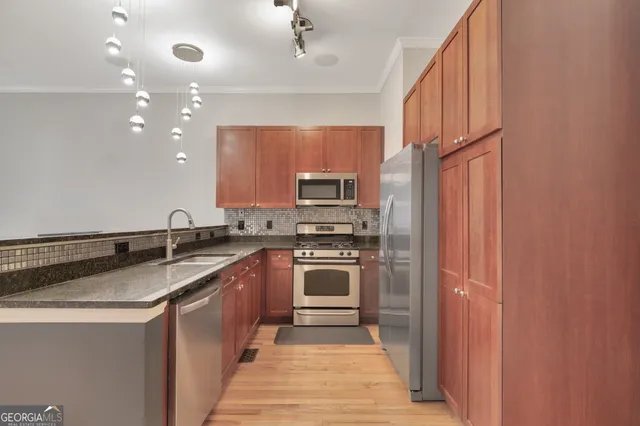 a kitchen with stainless steel appliances granite countertop a sink and stove top oven