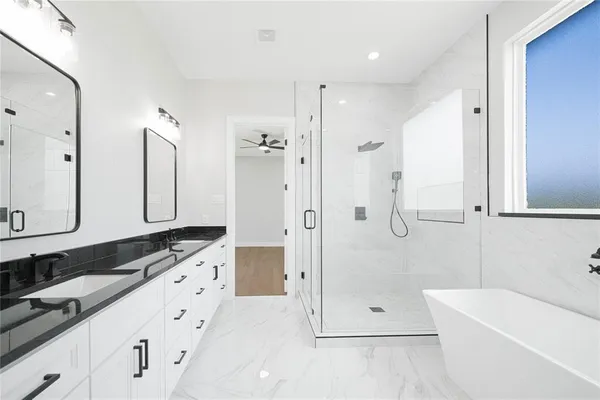 a bathroom with a granite countertop sink a large mirror and shower