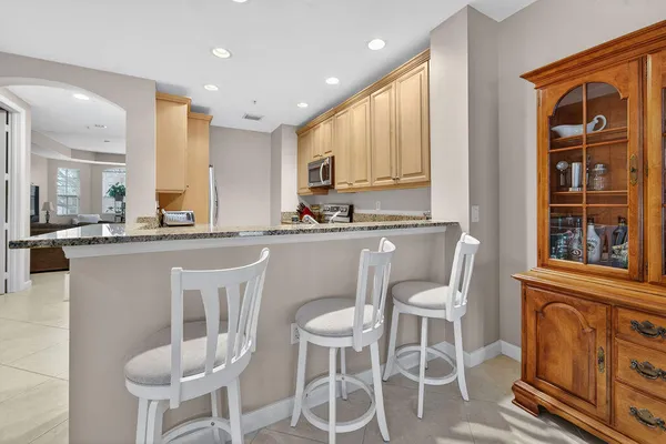 a kitchen with a dining table chairs and sink