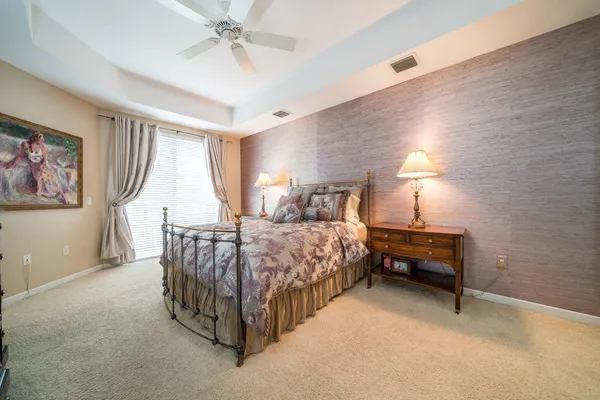 a spacious bedroom with a bed and a chandelier