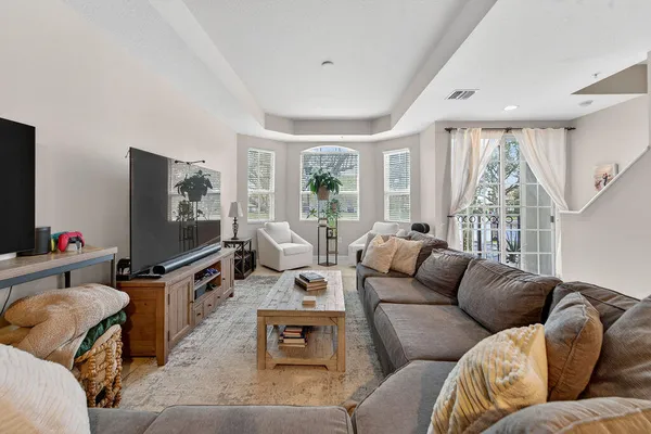 a living room with furniture flat screen tv and a large window