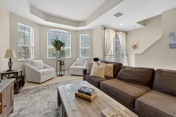 a living room with furniture and large windows