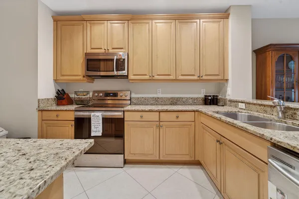 a kitchen with stainless steel appliances granite countertop a stove sink and cabinets