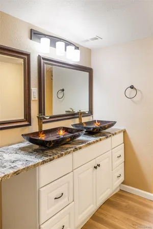 a bathroom with a granite countertop sink and a mirror