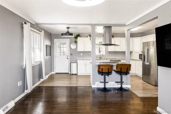 a kitchen with granite countertop white cabinets and stainless steel appliances