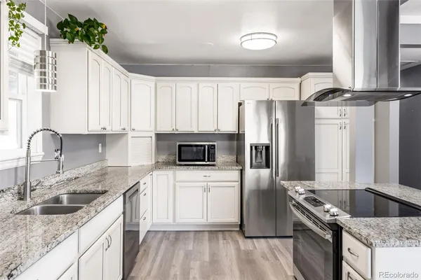 a kitchen with granite countertop a sink stove and refrigerator
