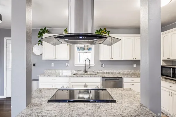 a kitchen with stainless steel appliances granite countertop a sink a stove and cabinets
