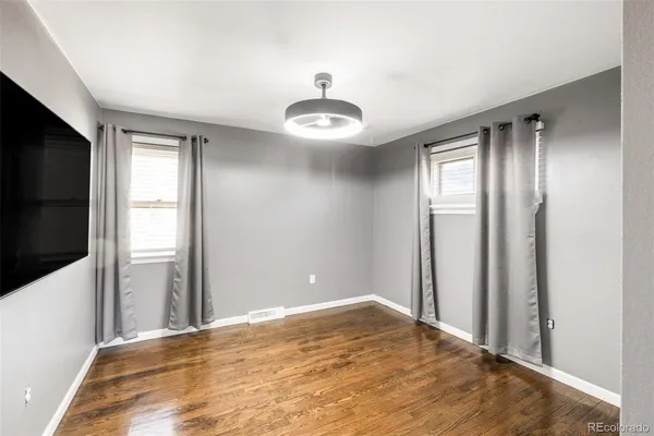 a view of a livingroom with wooden floor and a ceiling fan