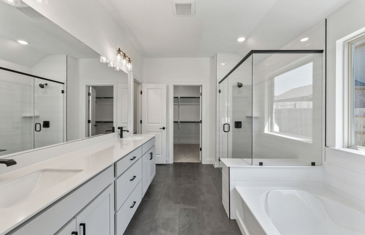 800 Crescent View Drive Georgetown, TX 78628 - Photo 16 of 36 a spacious bathroom with a double vanity sink a large mirror a shower and bathtub