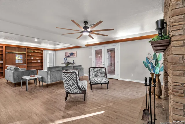 a living room with wooden floor and a fireplace