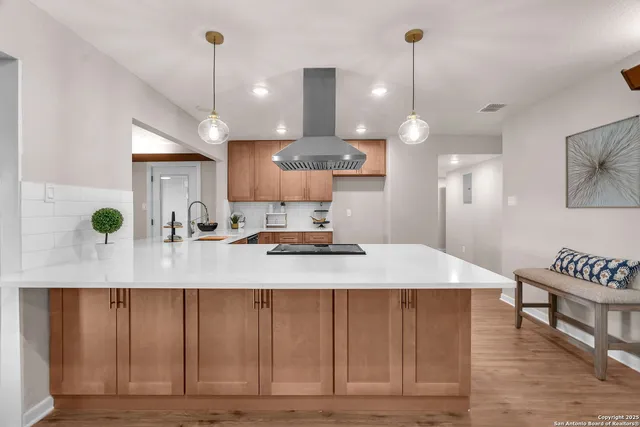 a kitchen with a stove cabinets and wooden floor