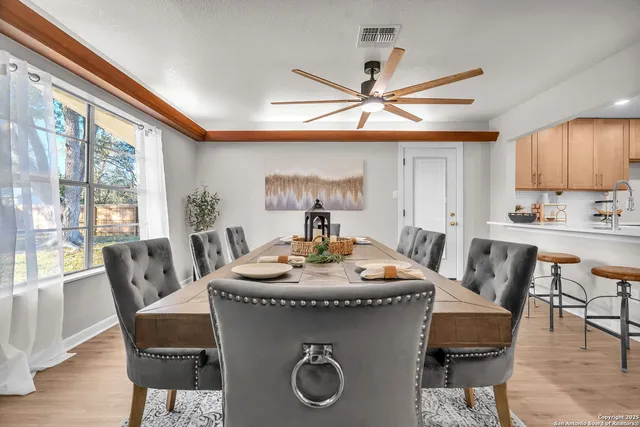 a living room with wooden floor and a ceiling fan