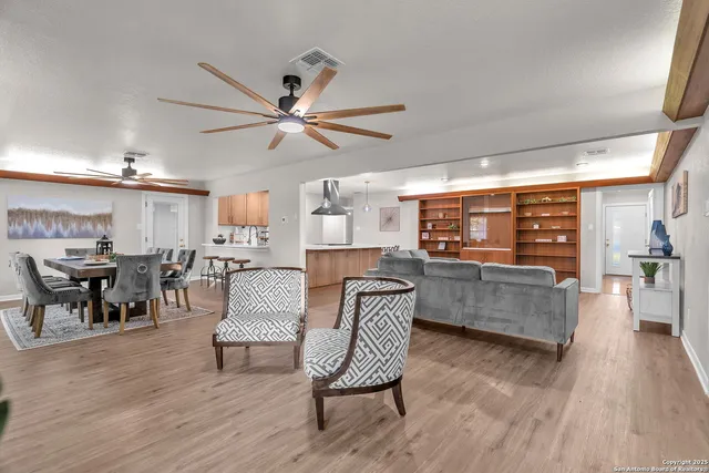 a dining room with furniture potted plants and wooden floor