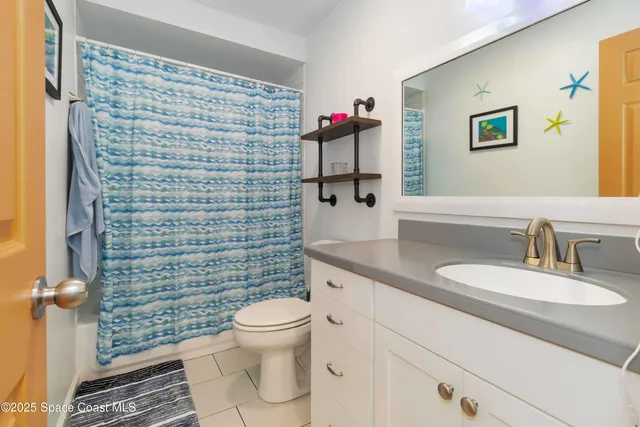a bathroom with a granite countertop toilet sink and mirror