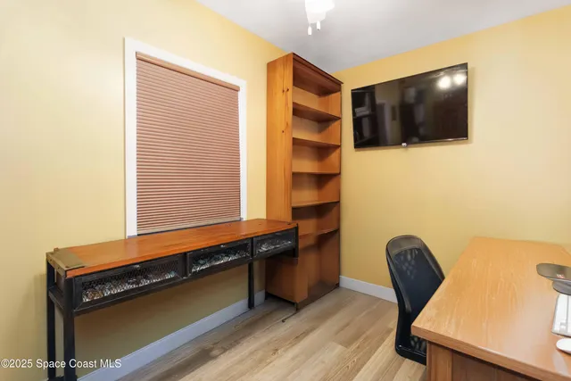 a reading room with wooden floor and furniture