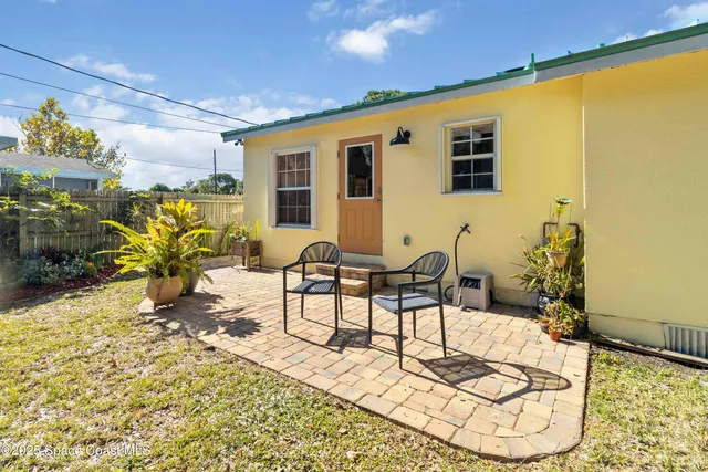 a view of a porch with chairs and potted plants